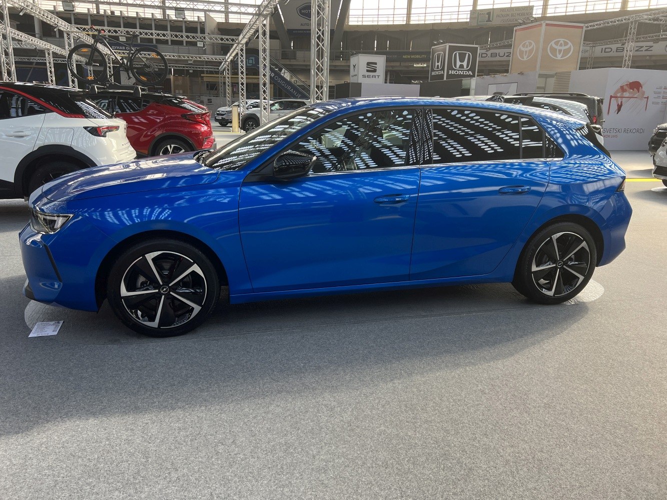 Blue hatchback with sporty alloy wheels and sleek side profile