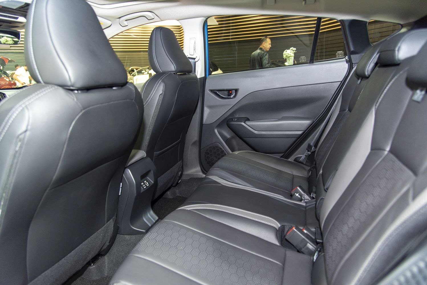 Black leather rear seats with spacious legroom and modern door panel.