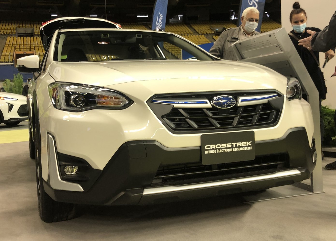 Front grille and headlights of a white SUV with hybrid badge