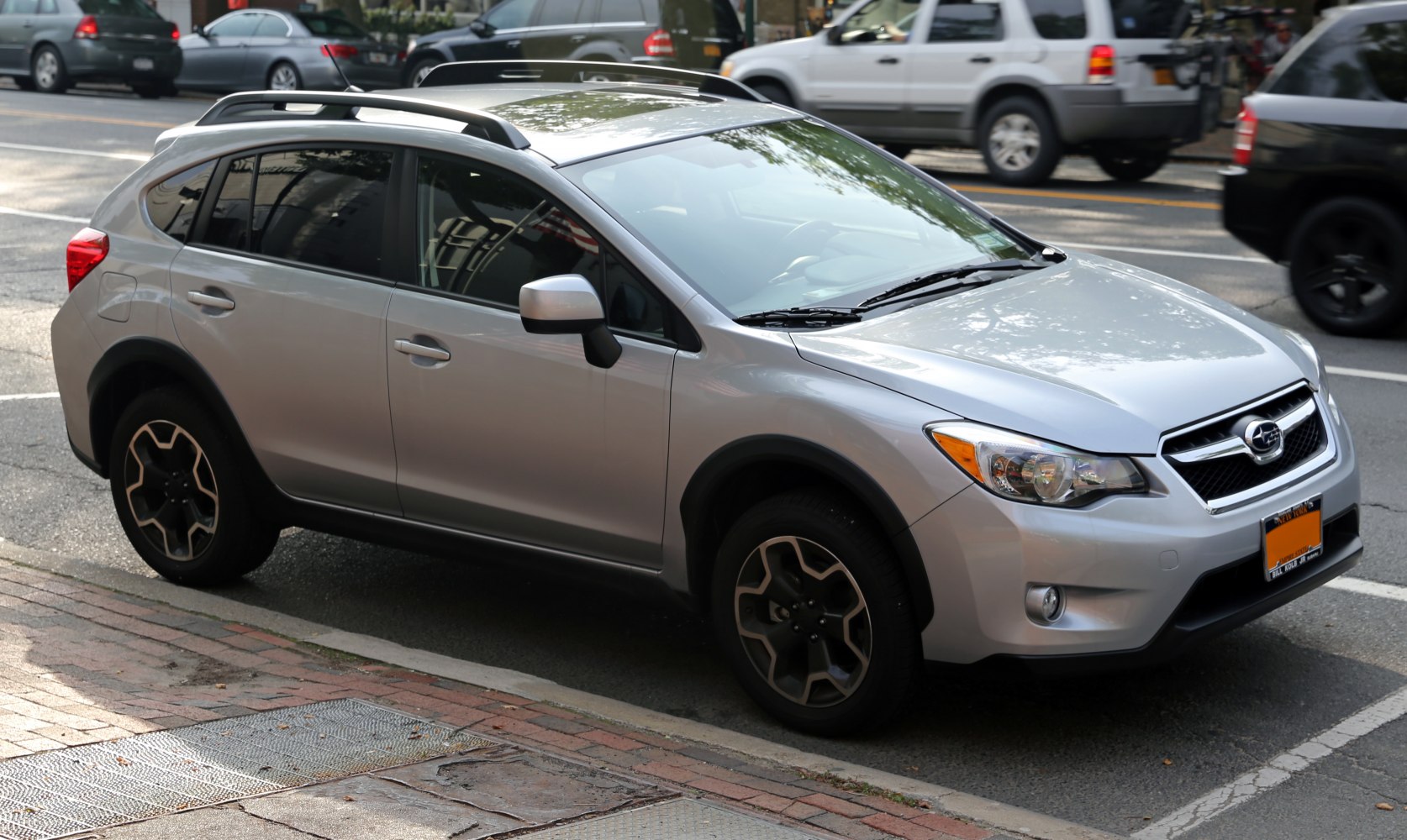 Compact crossover with roof rails and alloy wheels parked on street