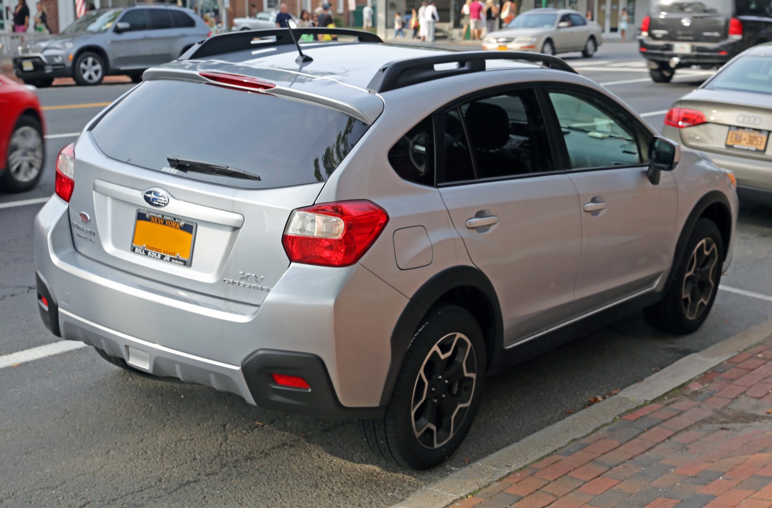 Rear and side view of silver crossover SUV with roof racks and alloy wheels