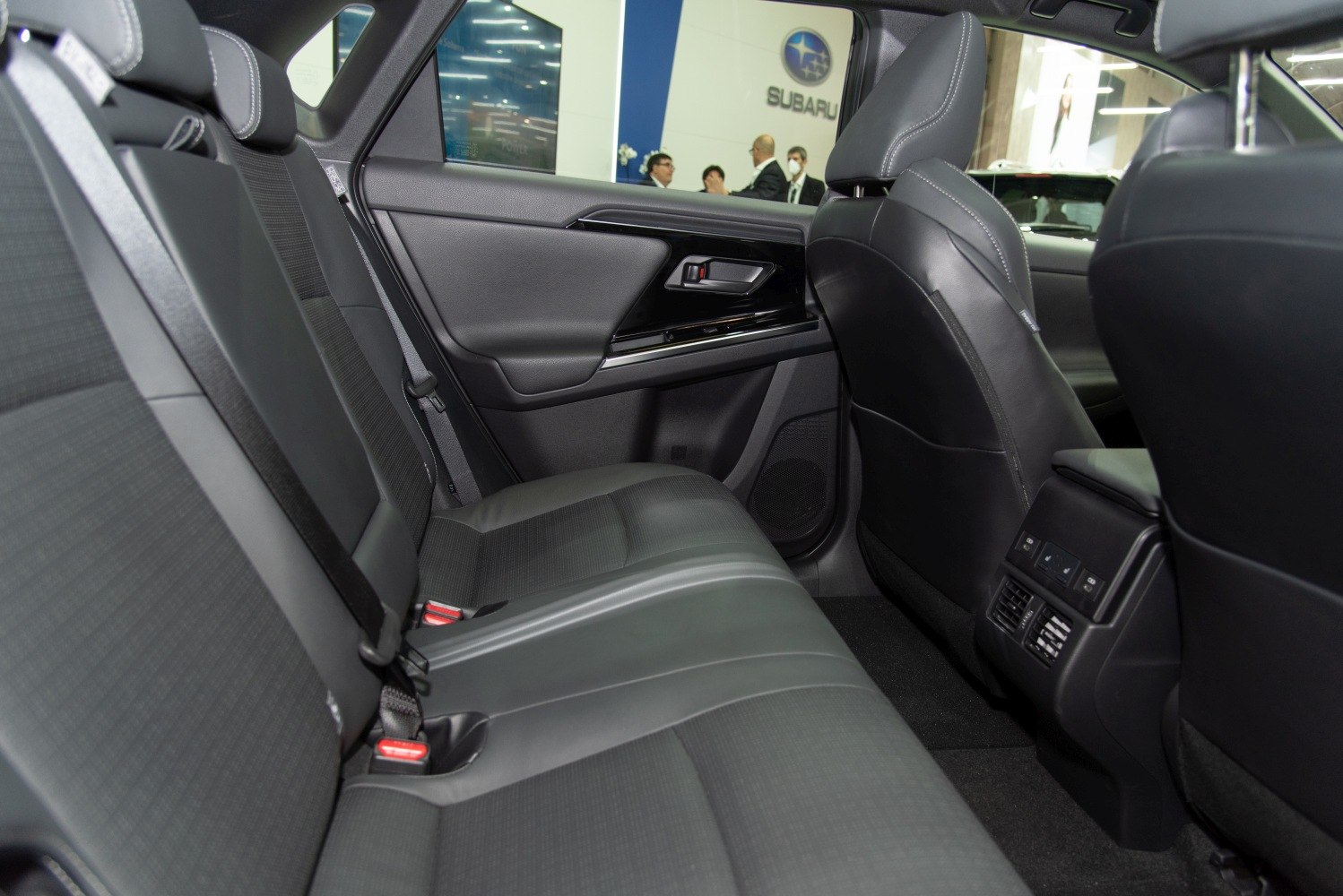 Rear passenger seating with black upholstery and rear climate control vents.