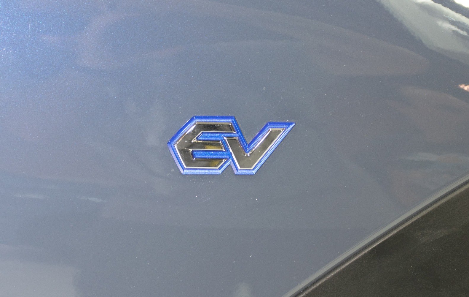Close-up of EV badge emblem on vehicle body