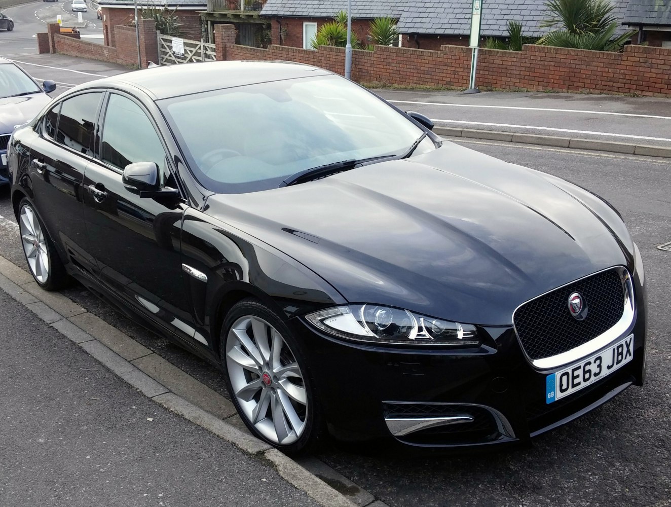 Sleek black sedan front side with modern headlights and alloy wheels