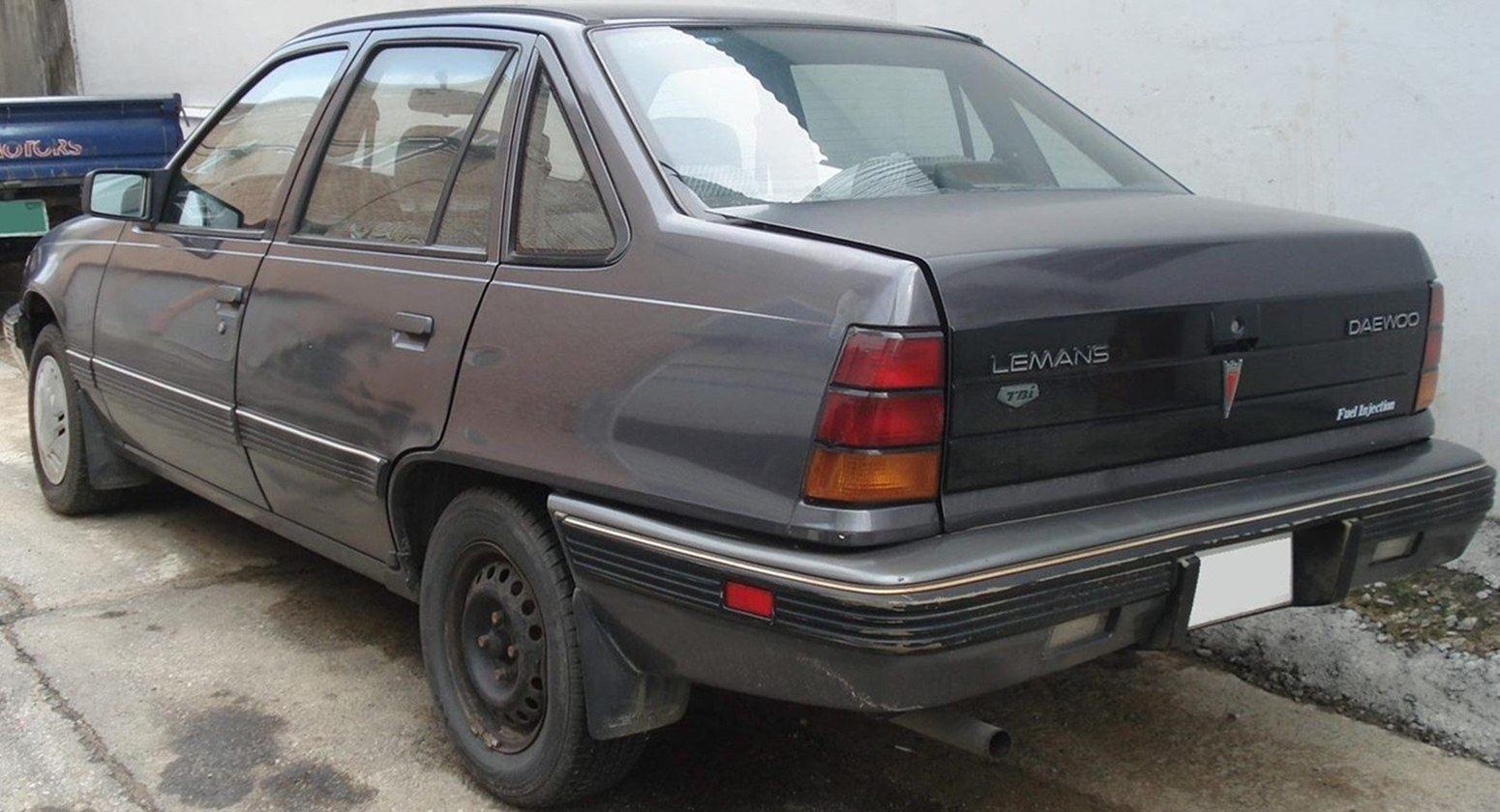 Rear and side view of classic sedan with vintage taillights and body design