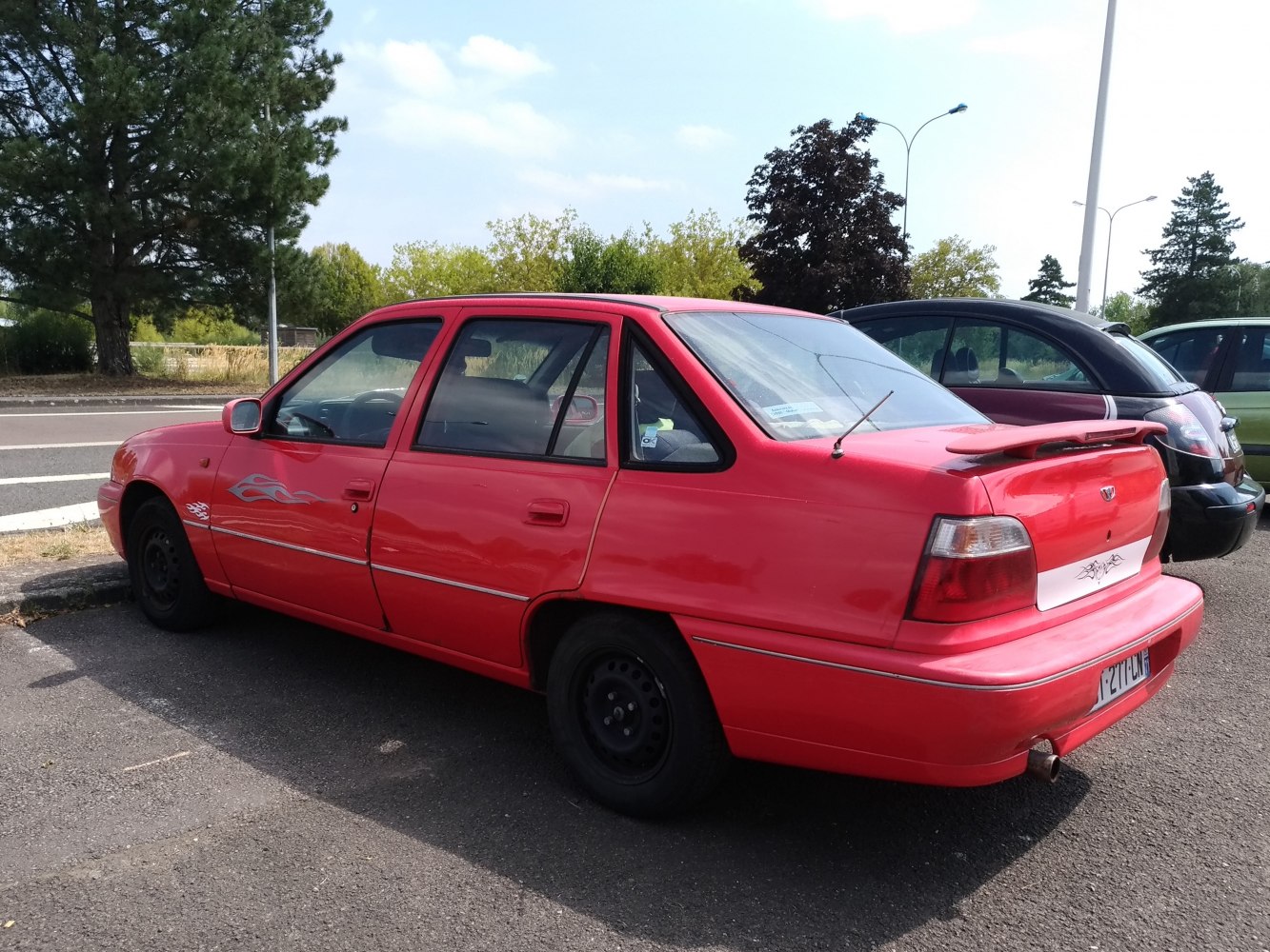 Red four-door sedan with rear spoiler and flame decals