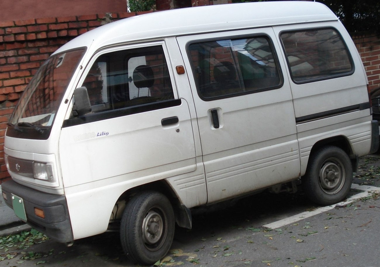Compact white mini van with sliding side door and large windows