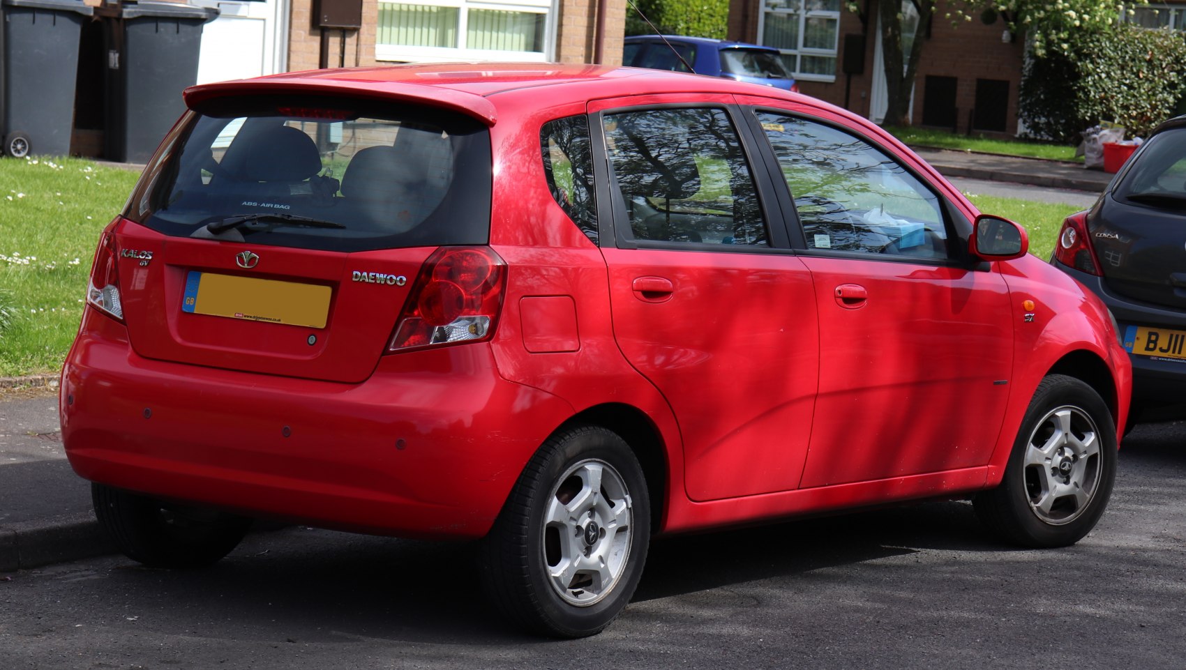 Red five-door hatchback with rear spoiler and alloy wheels