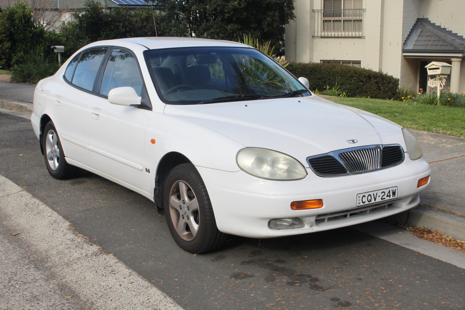 White sedan front view with distinctive grille and headlights