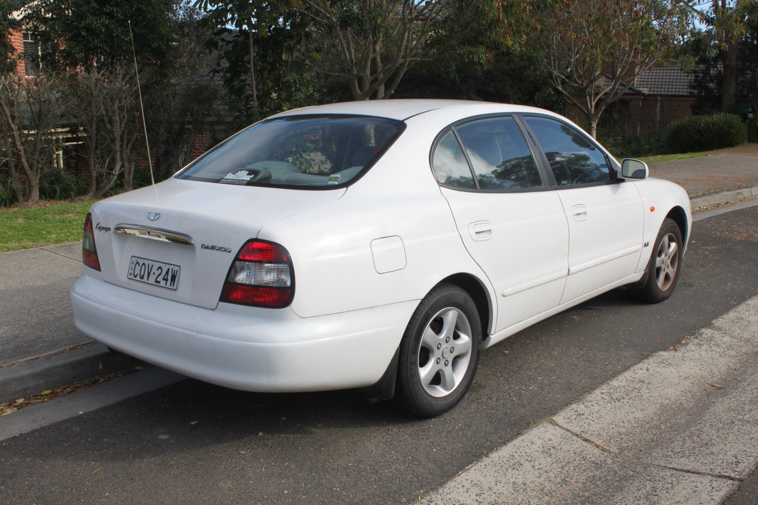 Rear and side view of a white sedan with distinctive taillights and alloy wheels.