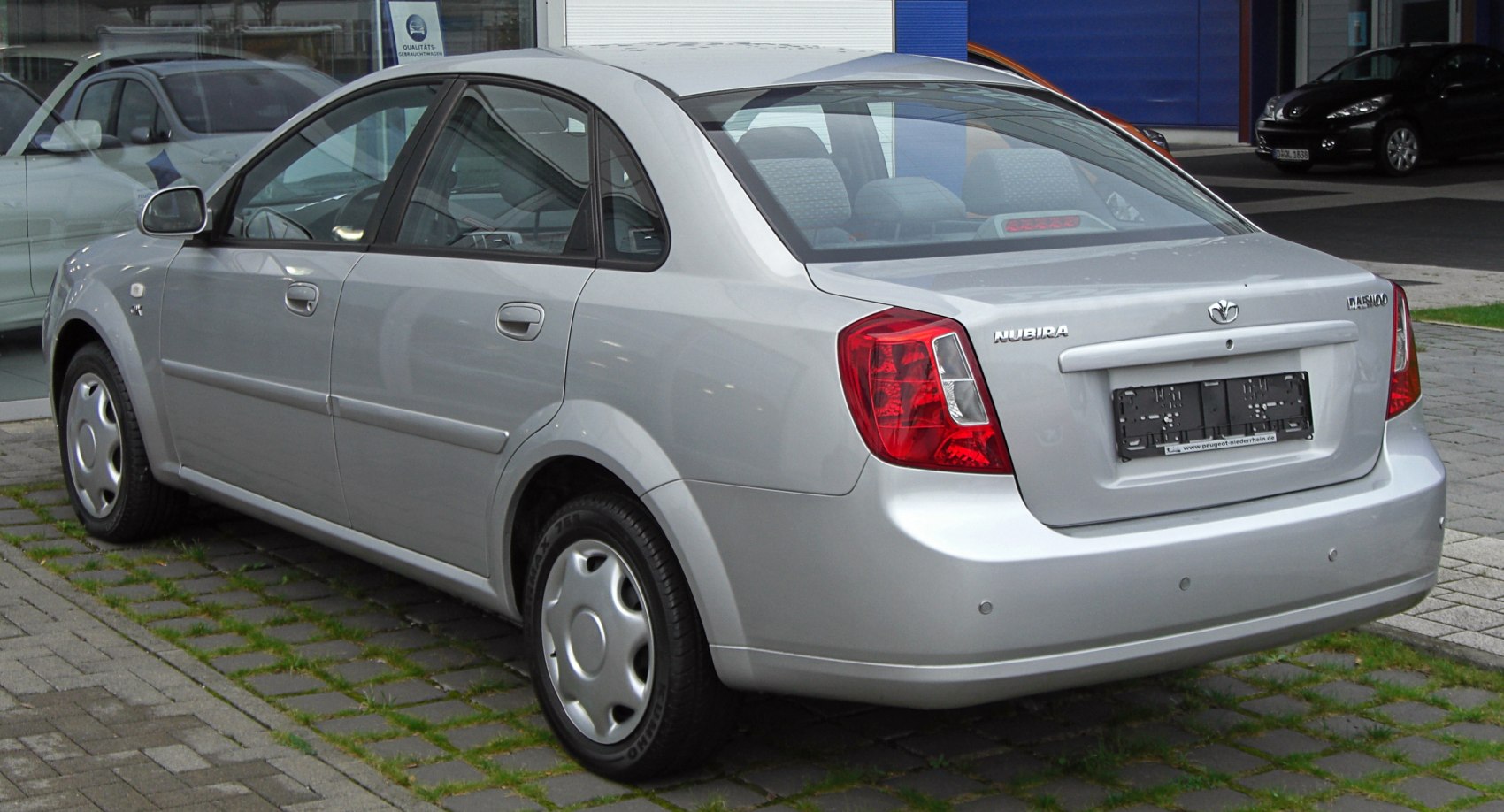 Rear view of silver sedan with rectangular tail lights and smooth body lines