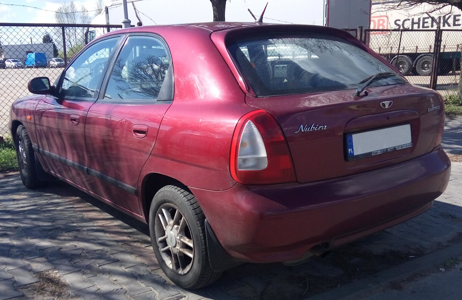 Red five-door hatchback with distinctive rear taillights and rear windshield wiper