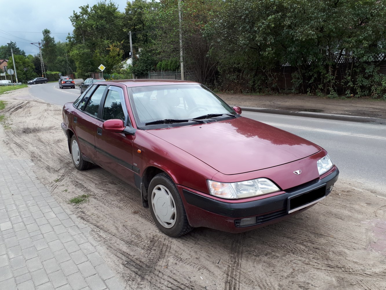 Front quarter view of a vintage sedan with clear headlights and classic hubcaps.