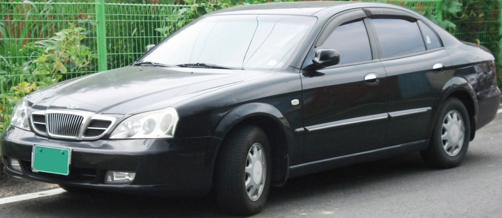 Black sedan showing front and side views with grille and headlights