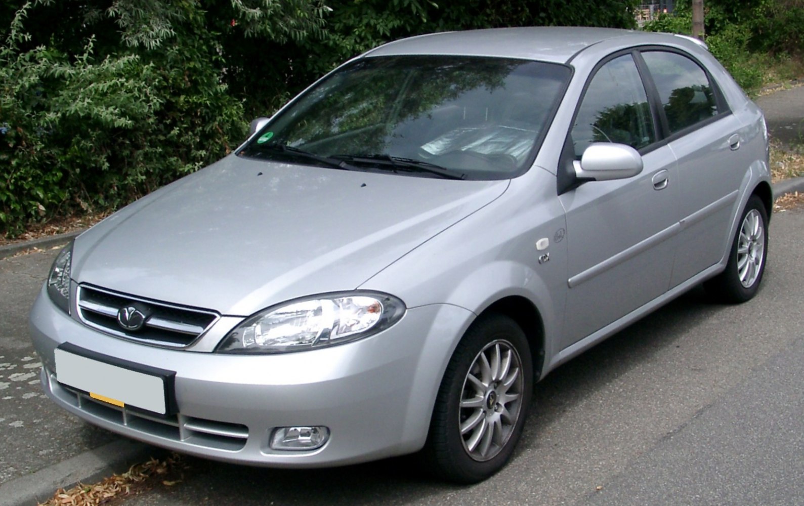 Silver hatchback front side view with clear headlights and alloy wheels