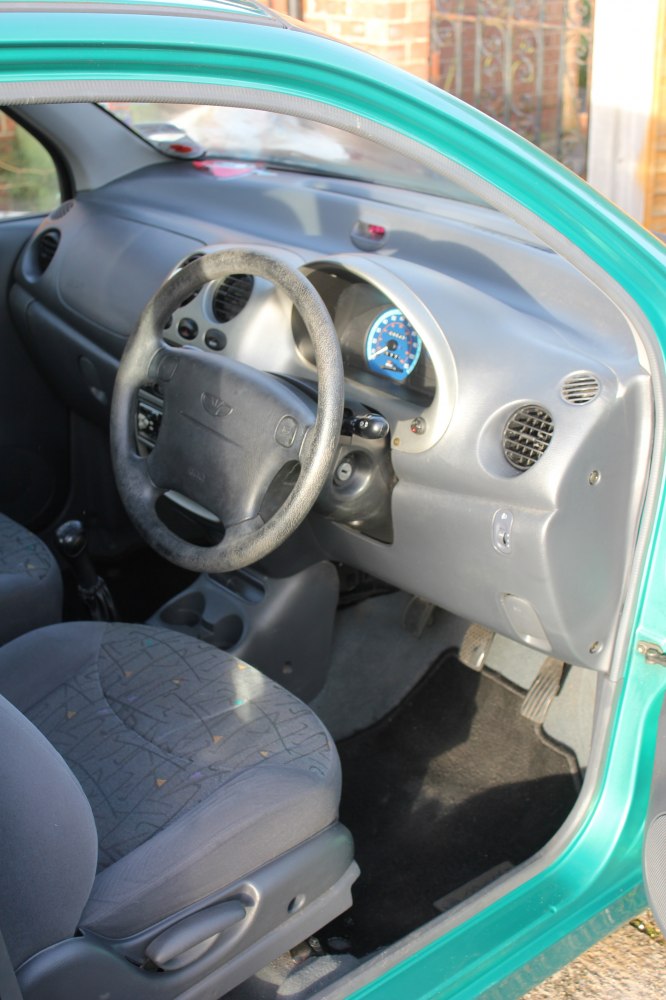Dashboard, steering wheel, fabric seats of compact car interior