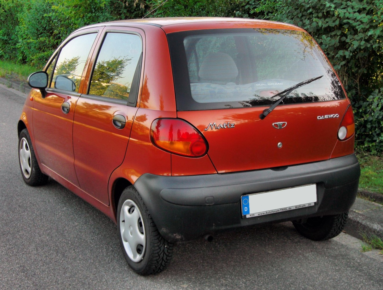 Compact hatchback rear side with rounded taillights and black bumper trim