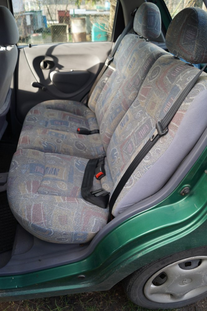 Rear seat upholstery and seat belts with patterned fabric in compact car interior