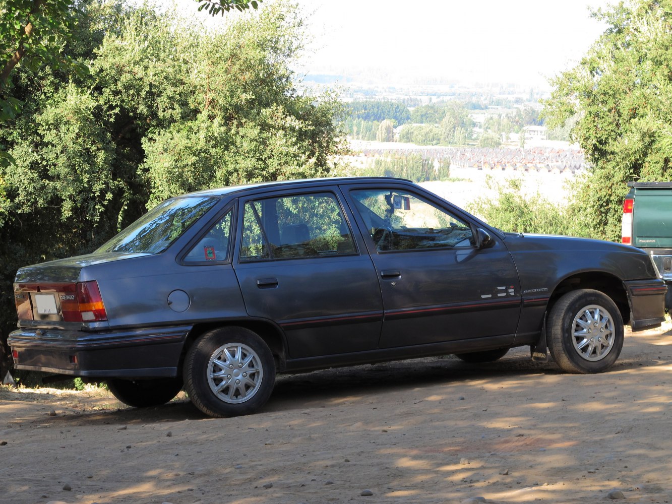 Side view of a four-door sedan with alloy wheels and classic rear design.