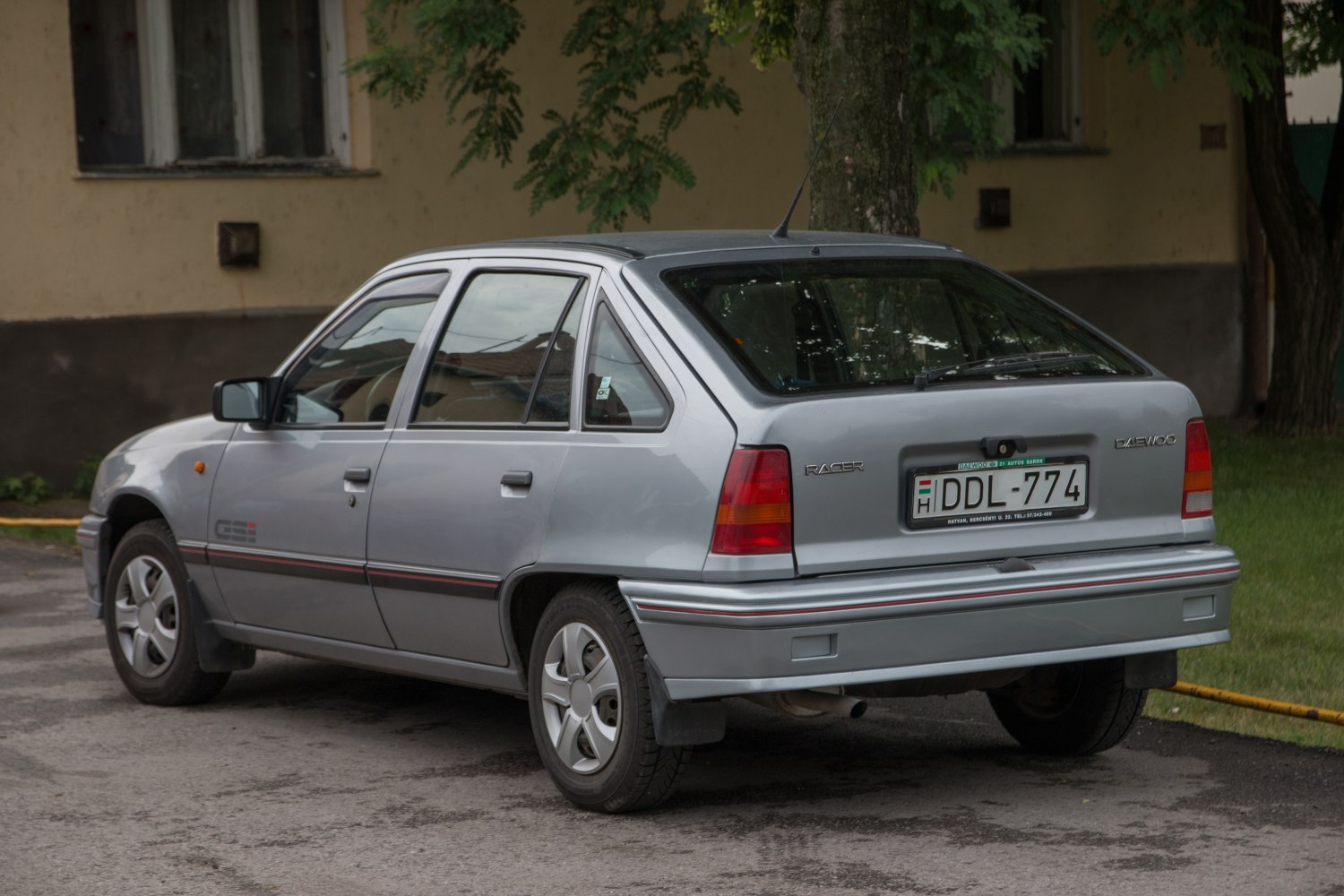 Rear and side view of a vintage hatchback with alloy wheels and roof antenna
