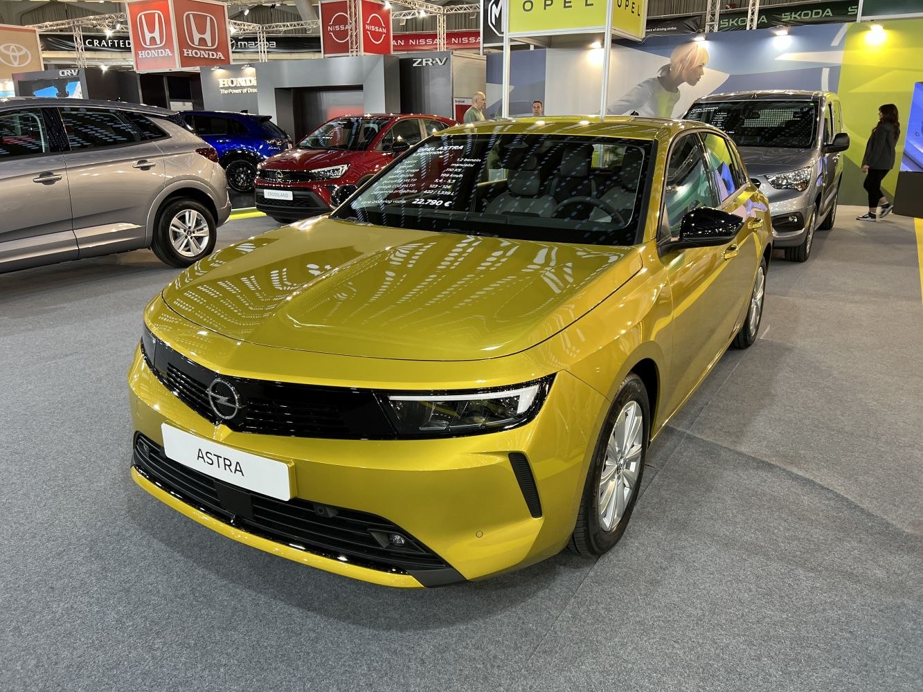 Yellow hatchback with sleek front and modern headlights.