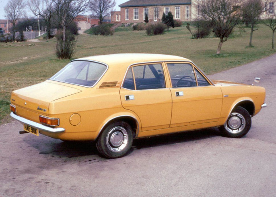 Rear side profile of classic 1970s sedan with chrome hubcaps and boxy design