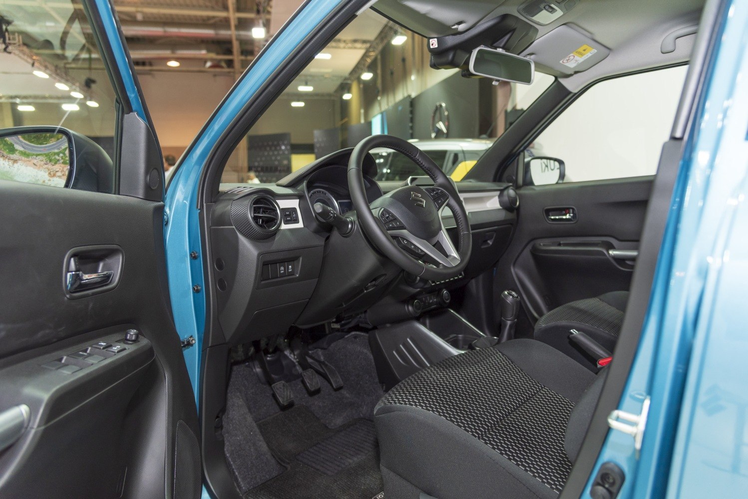 Steering wheel, dashboard, front seating and door panel of compact car interior.