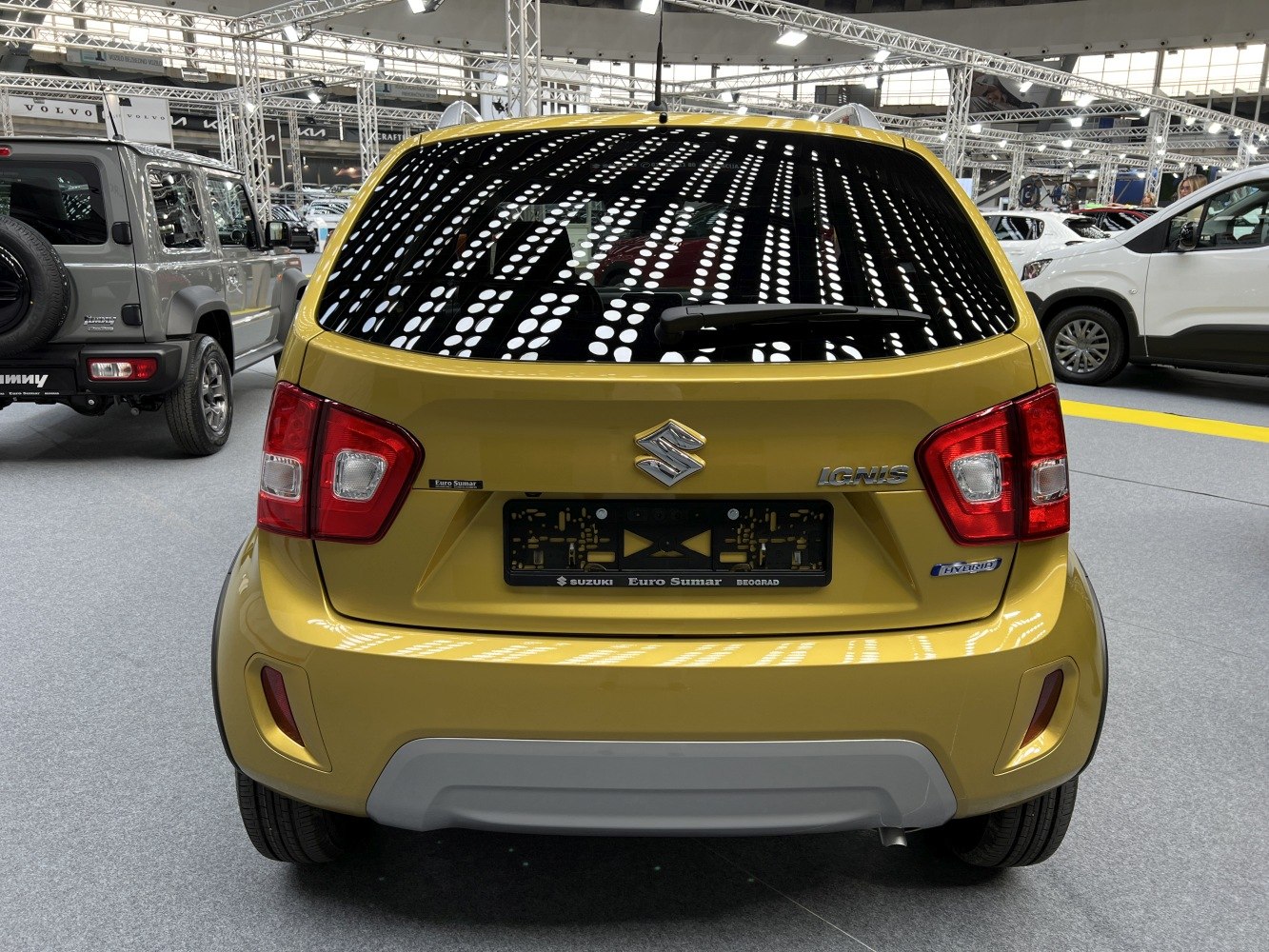 Rear view of yellow compact hatchback with hybrid badge and distinct taillights
