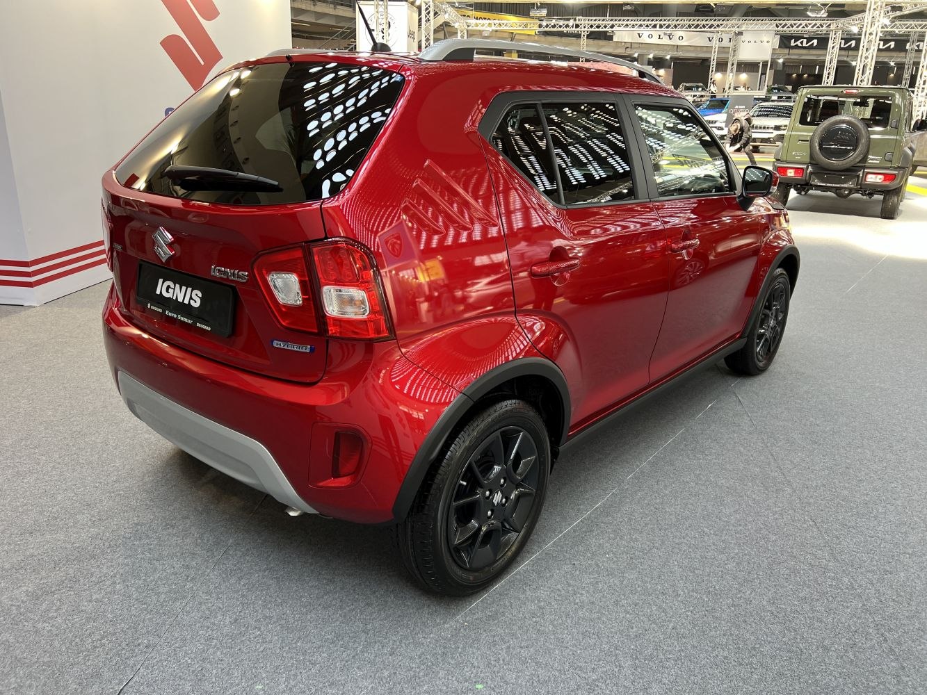 Rear-side view of red compact hybrid SUV with black wheels