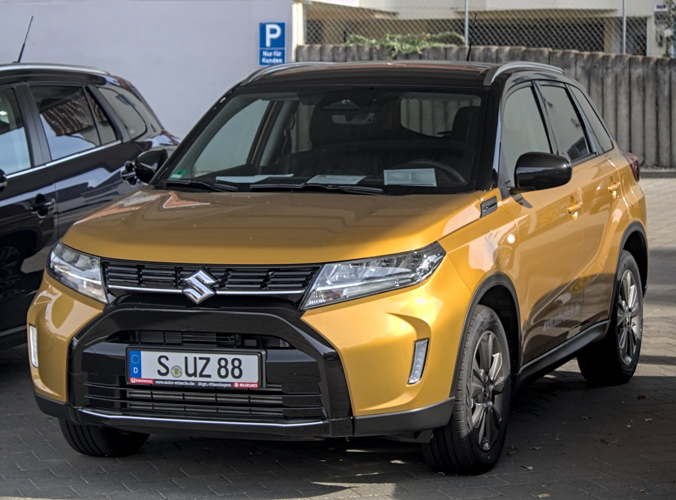 Front view of gold SUV with black roof and sleek headlights
