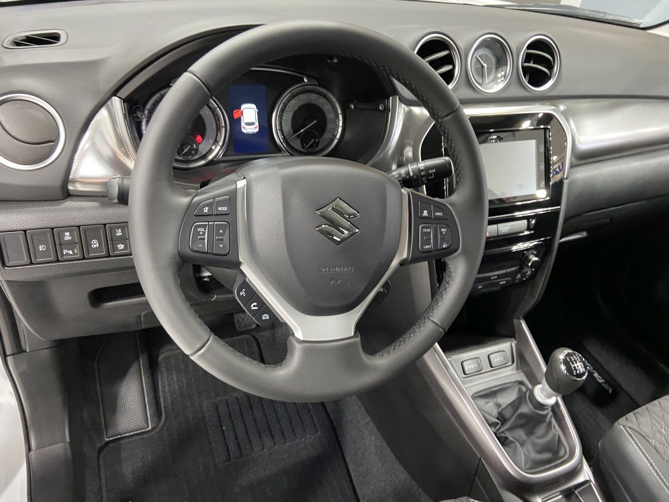 Steering wheel with control buttons and manual gear shifter in car interior