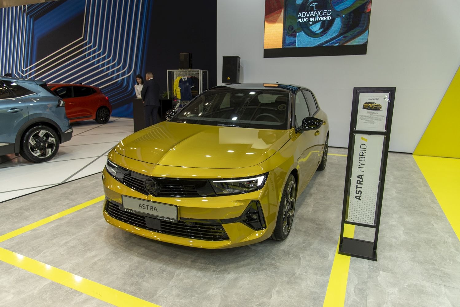 Sleek front view of a yellow sporty hatchback with hybrid branding