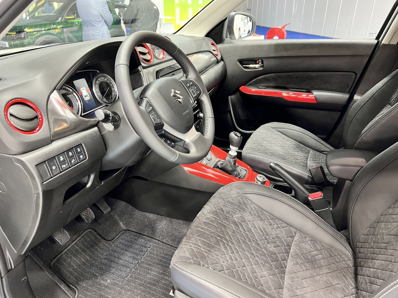 Interior with manual gear lever and red trim accents.