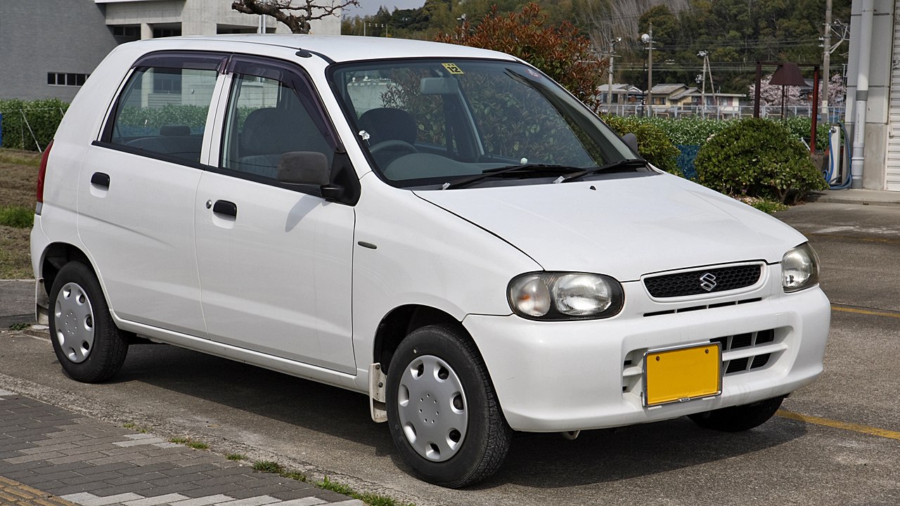 Compact white hatchback with rounded headlamps and simple body lines