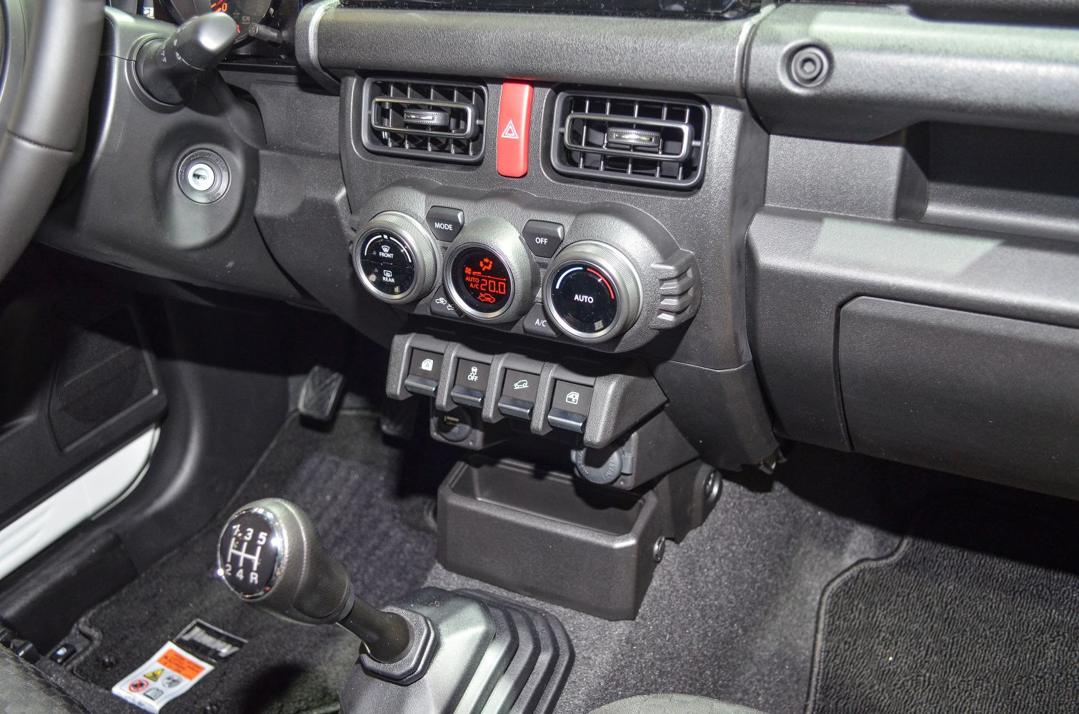 Manual gear shifter and climate control panel with air vents and control switches