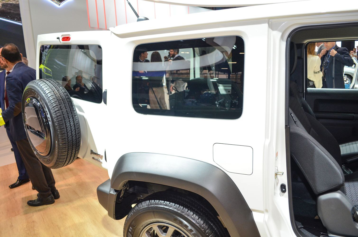 Rear side of compact 3-door off-road vehicle with spare tire and black wheel arch fender