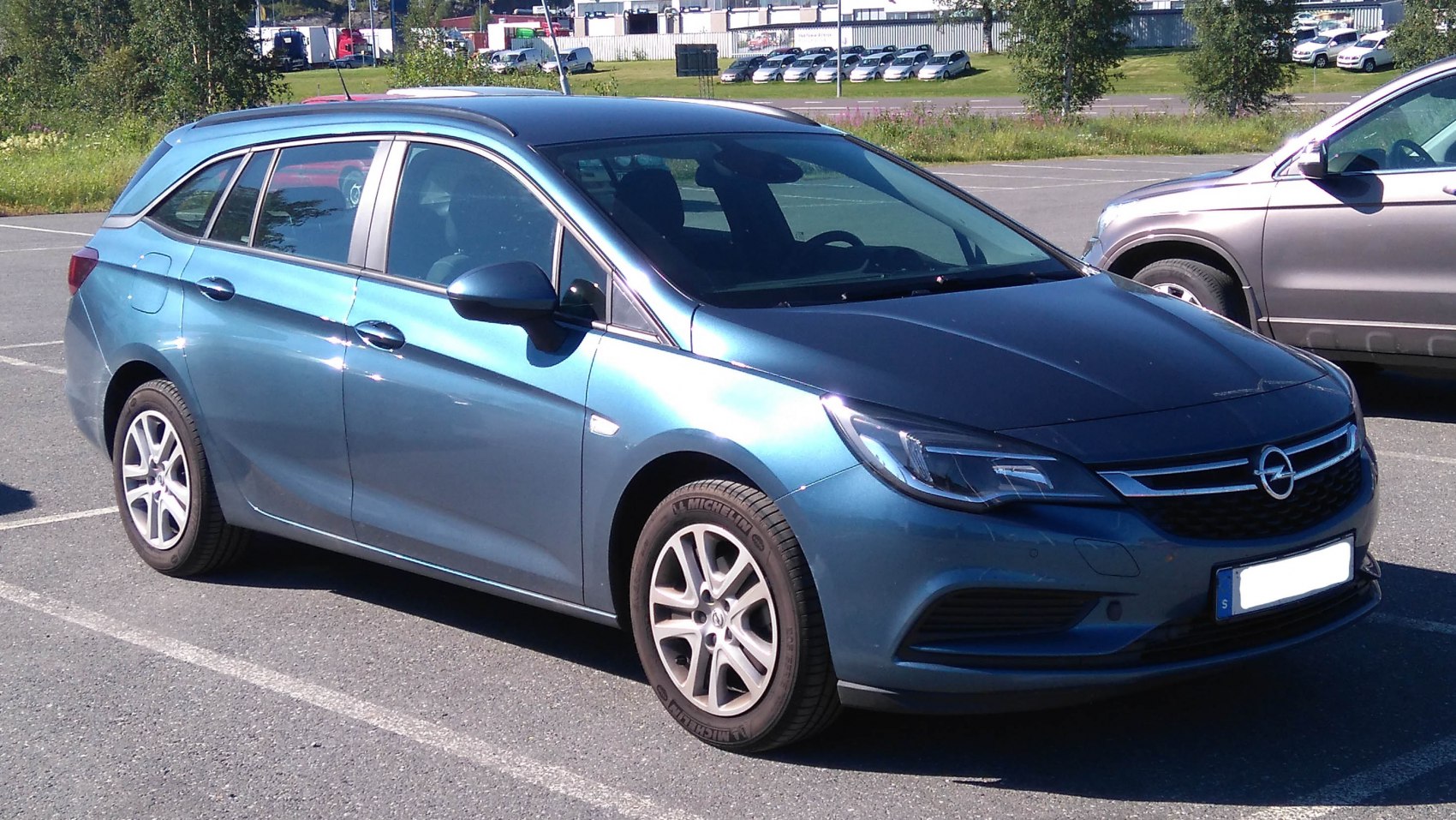 Front side view of a blue estate car with alloy wheels