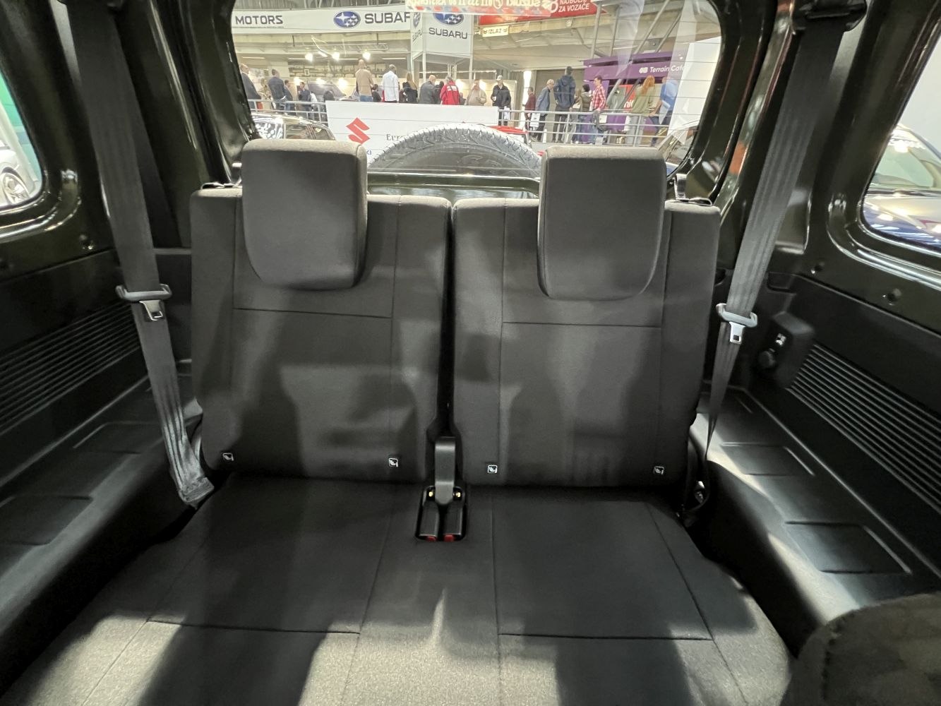 Rear seat interior with compact two-seat layout and seat belts