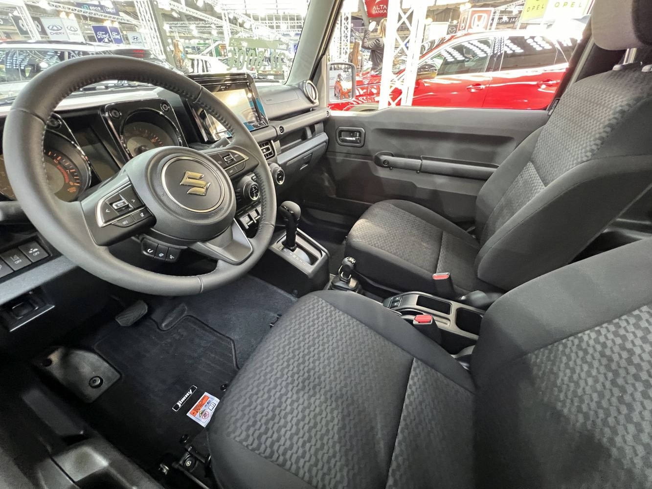 Steering wheel, dashboard with gauges, and patterned fabric seats