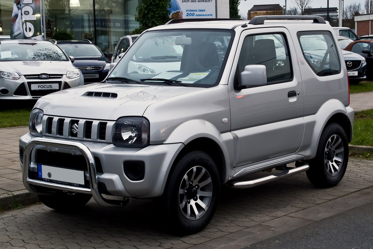 Front and side view of compact SUV with grille, hood scoop, and roof rails