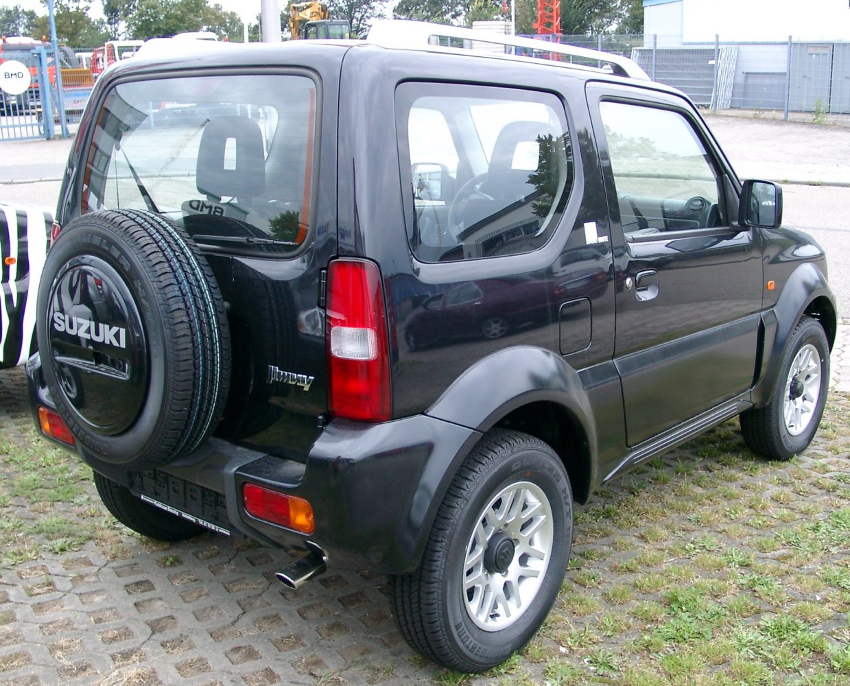 Rear side view of compact SUV with mounted spare wheel