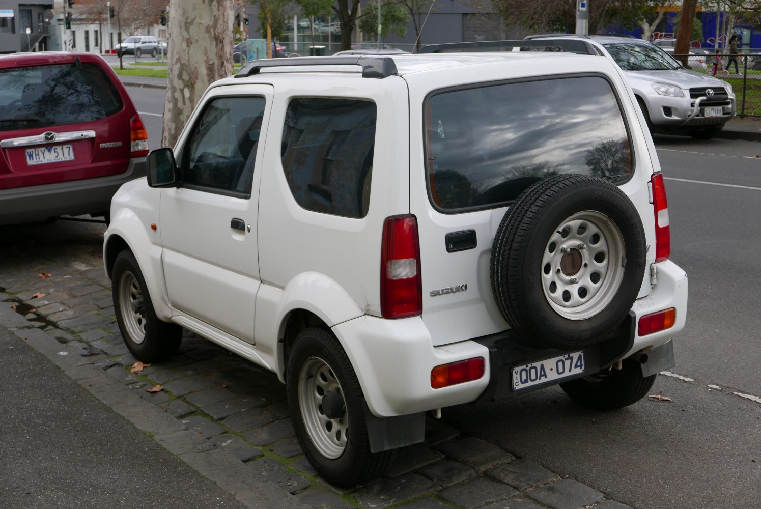 Rear view of a white compact SUV with rear spare wheel and roof rails