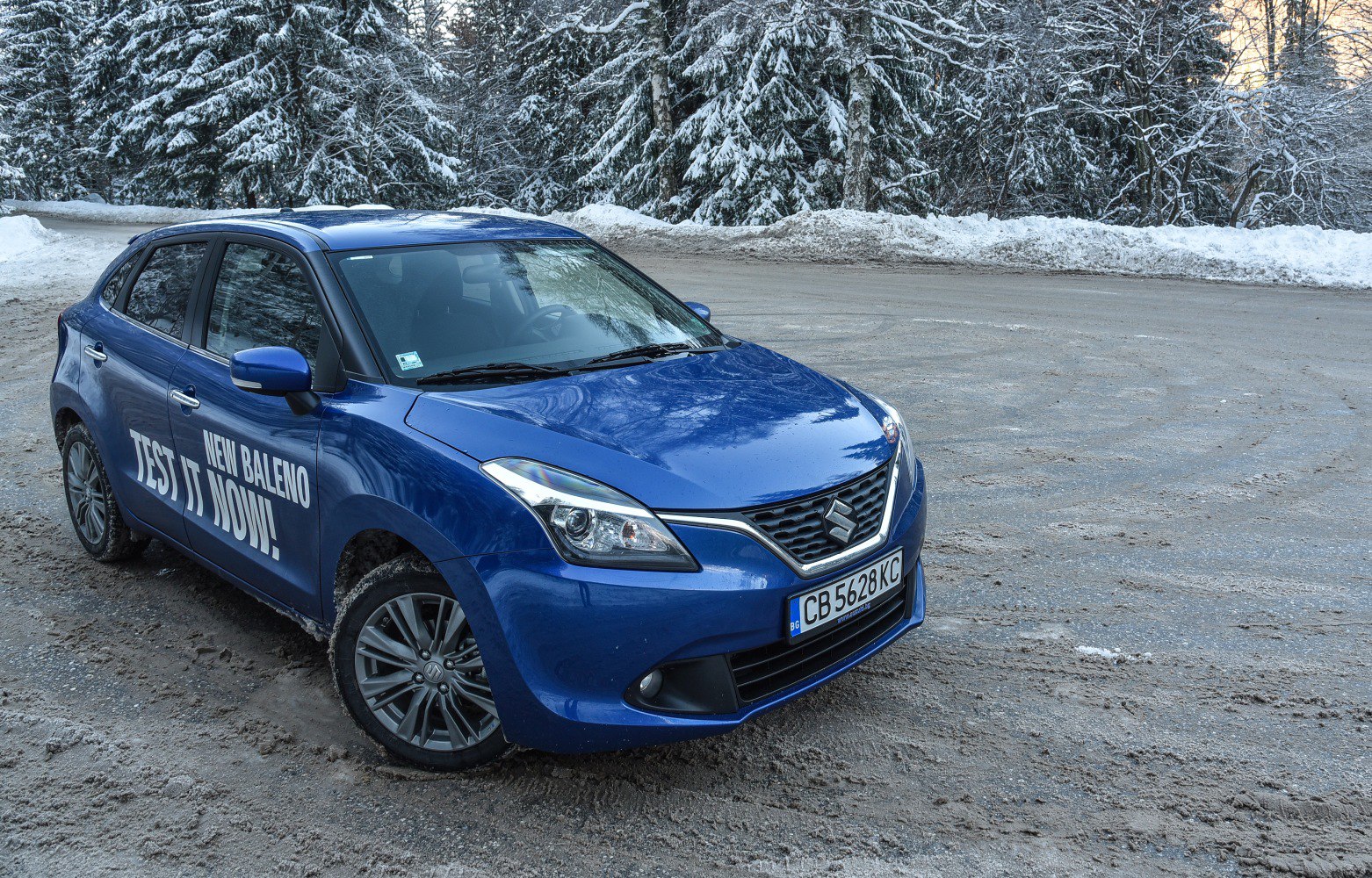 Front and side view of hatchback with alloy wheels and promotional text.