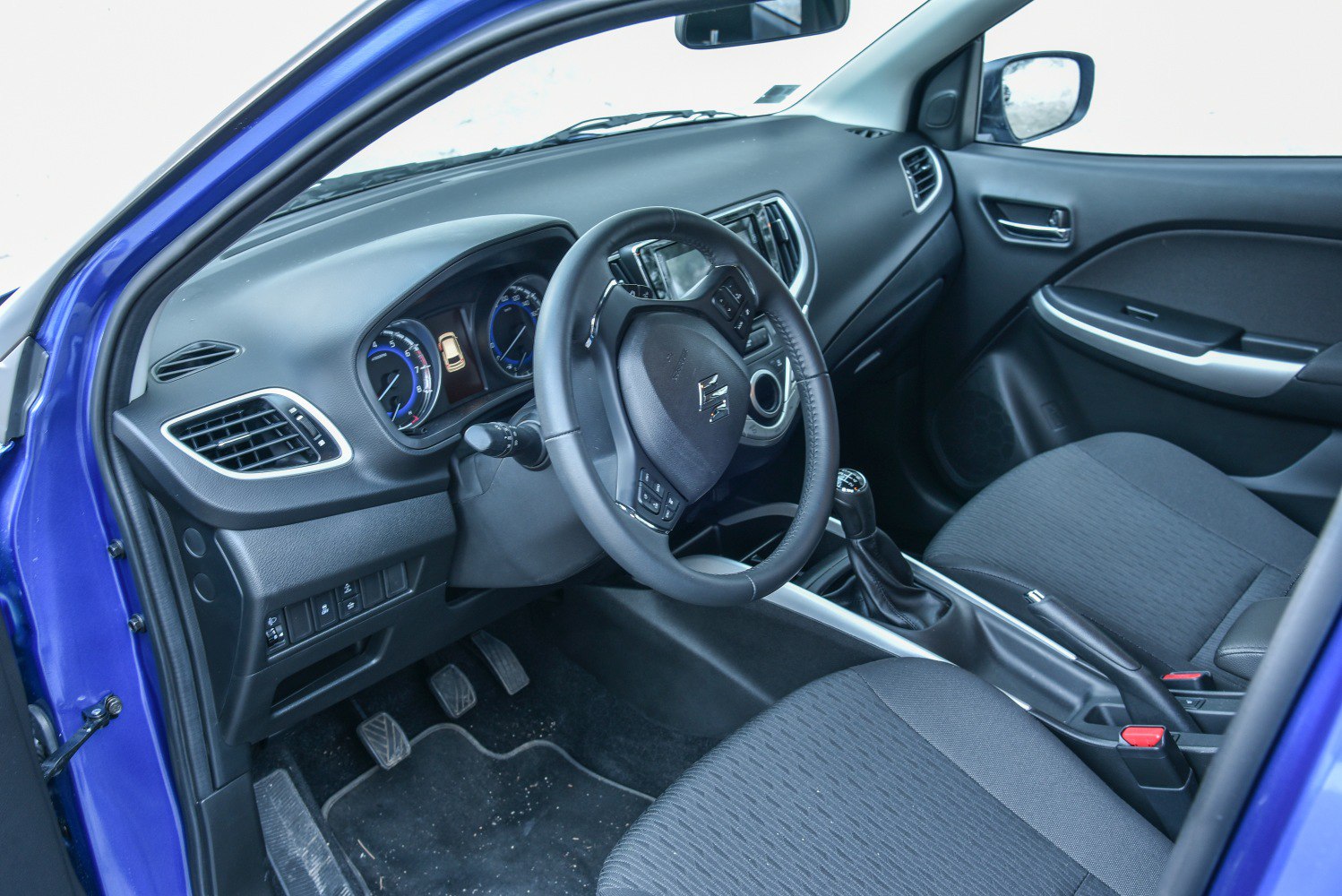 Dashboard, steering wheel, manual gear stick, and front seats interior details
