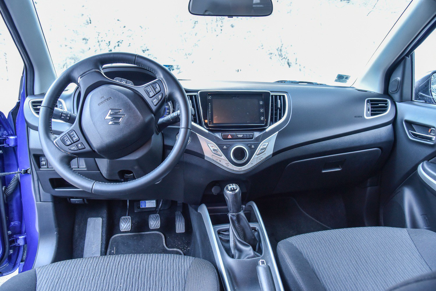 Steering wheel with controls and manual gearshift in car interior