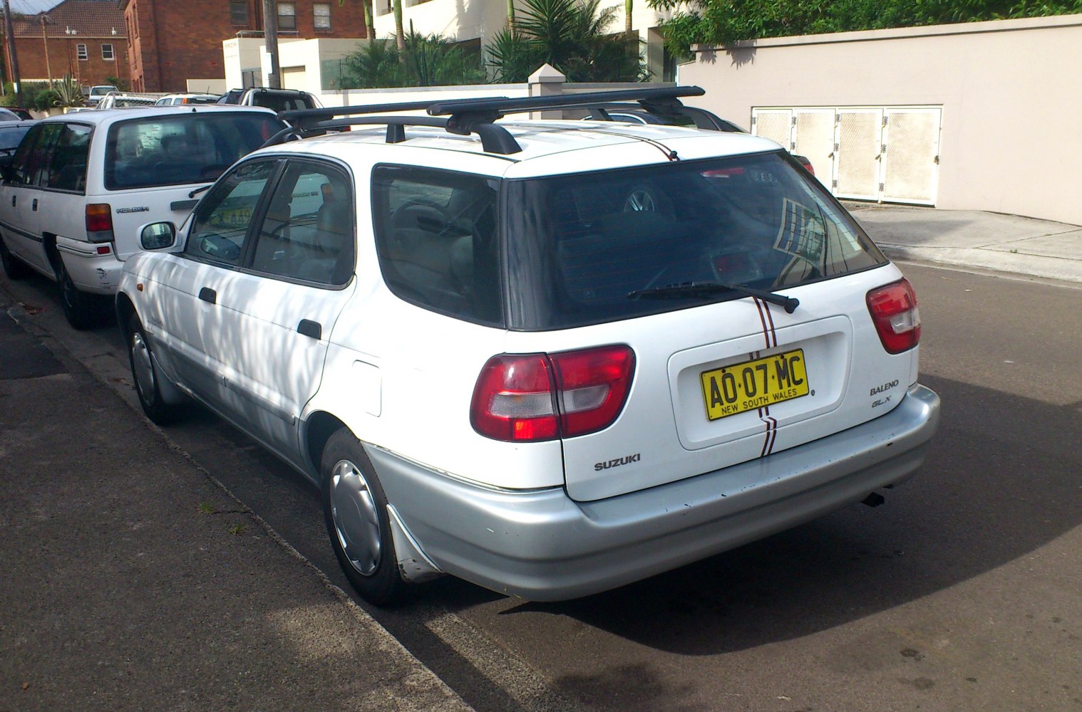 Rear side view of hatchback with roof rails and dual-tone bumper