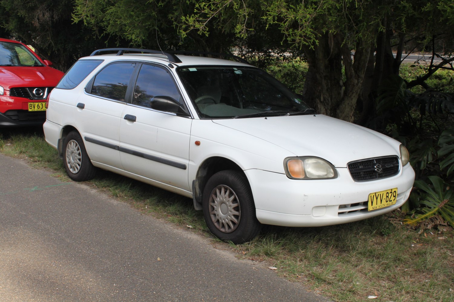 White mid-size station wagon with roof rails and hubcaps.