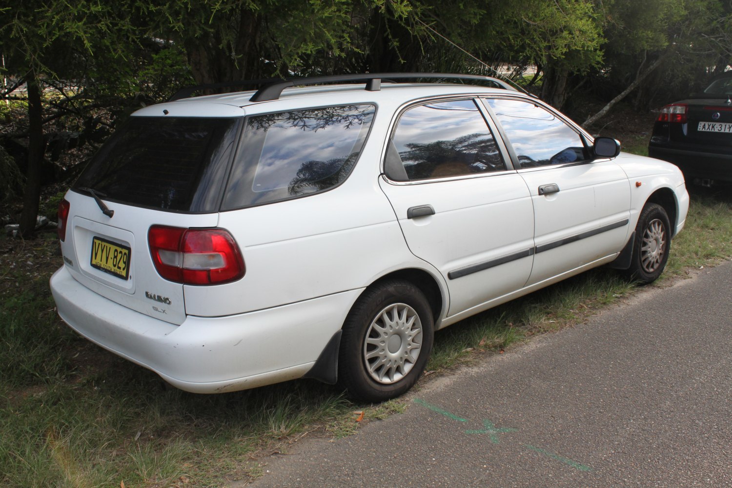Rear side view of a 90s station wagon with roof rails.