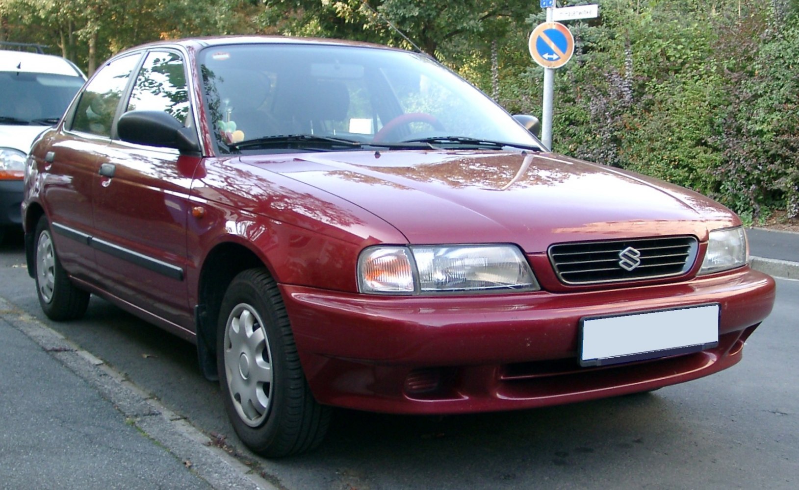 Front side profile with headlights and grille of a red compact sedan