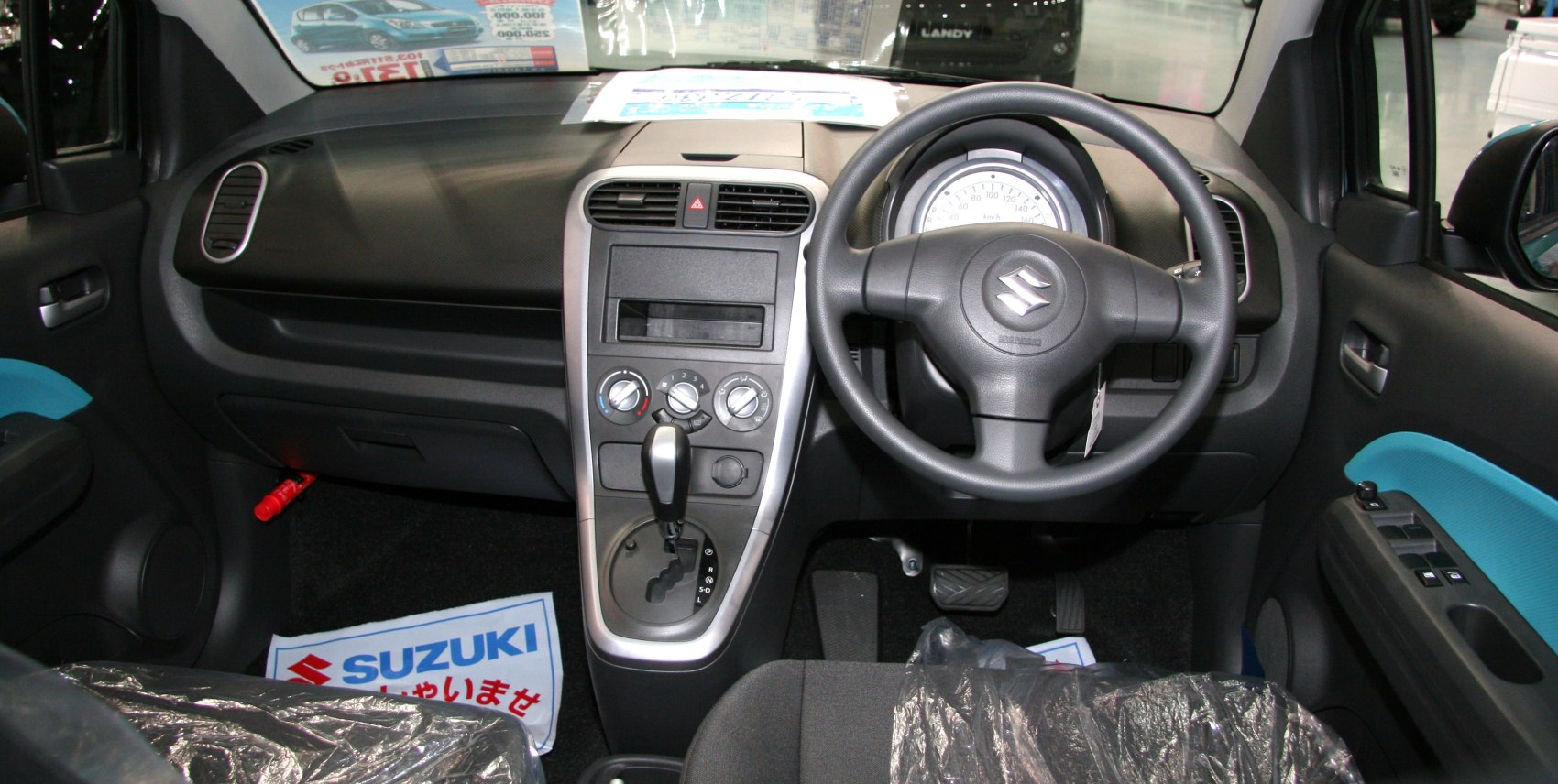 Compact car interior focusing on dashboard, steering wheel, and gear shift controls
